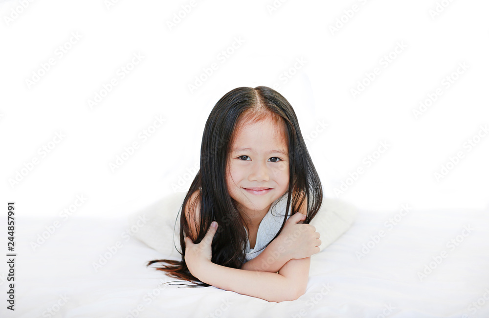 Happy beautiful Asian child girl lying on bed against white background. Happy beautiful Asian child girl lying on bed against white background.