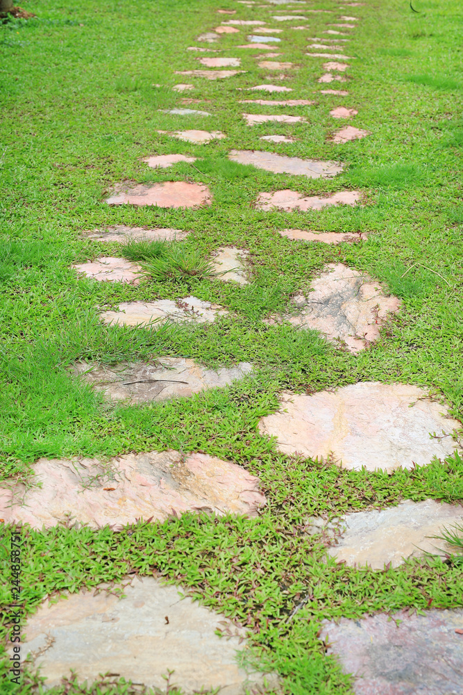 Stone pathway in the park with green grass around. Stone pathway in the park with green grass around.
