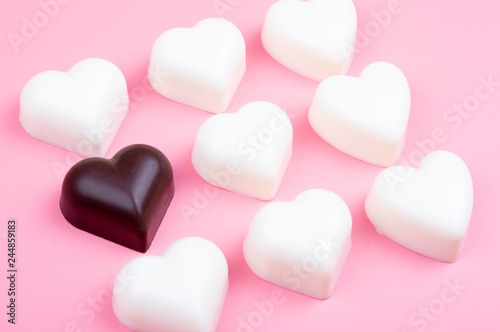 white and black heart chocolate on colored background