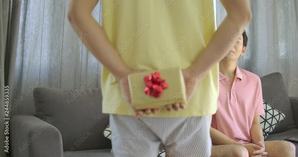 Valentine's Day gift. Yong asian gay giving Valentine gift box to his boyfriend. Holiday gift. Happy couple.