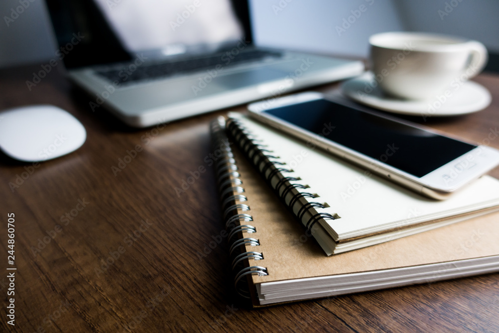 Close up office desk table with laptop, note book, mobile coffee and pen. Selective focus. Business concept. Copy space. Close up office desk table with laptop, note book, mobile coffee and pen. Selective focus. Business concept. Copy space.