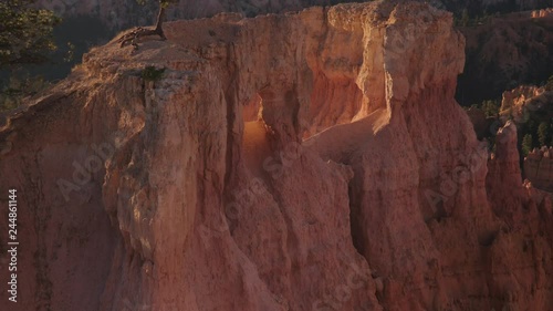 Beautiful view at Bryce Canyon National Parkof early morning light shining through gaps in the rocky spires.  Camera tilts up. photo