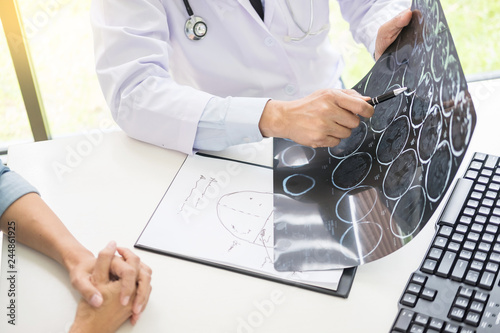 Fotografia doctor analyzing a scan or x-ray film or explains a CT scan thoughtful expressions method talking to patient treatment on brain to an anomaly