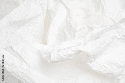 Subtle textures created by the folds and creases of a white spread out tissue paper.