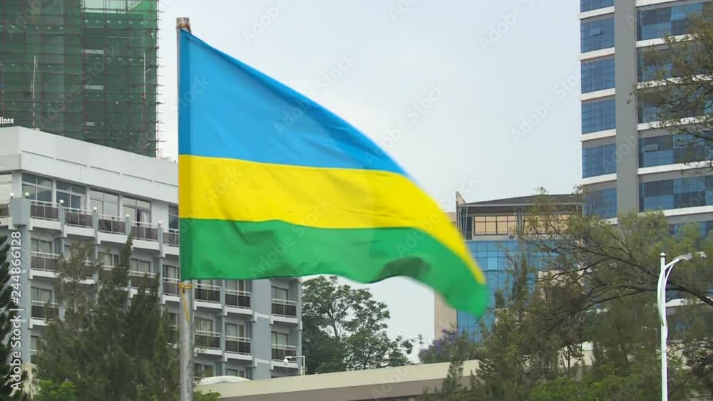 True Rwanda textile flag floating in front of modern Kigali buildings