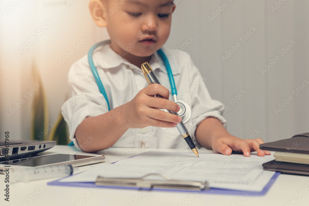 Young asian boy playing doctor and using computer laptop. Young asian boy playing doctor and using computer laptop.