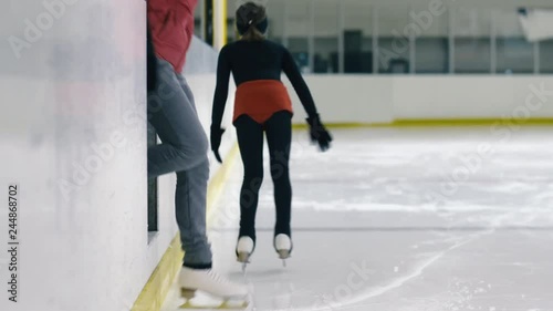 Wallpaper Mural Rear view shot of girl in figure-skating suit going out on the ice inside ice rink and her trainer following her Torontodigital.ca
