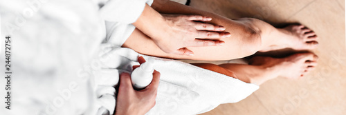 Wallpaper Mural The girl in the bathroom puts anti-cellulite cream, serum on the legs and body. Body care concept. Top View. Banner Torontodigital.ca