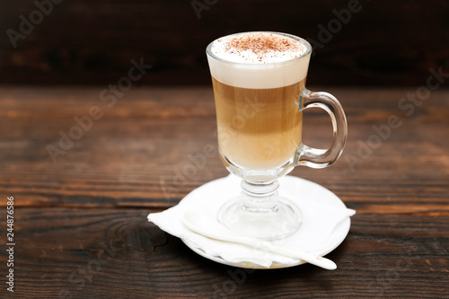 Cappuccino with cinnamon. Cup of coffee on wooden background