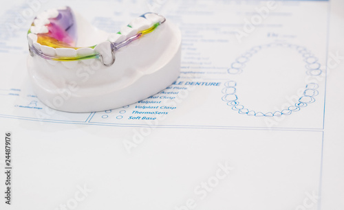 Dental retainer orthodontic appliance on the colour background.