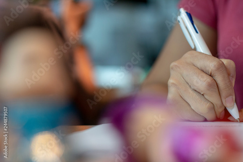 female hands with pen writing on notebook