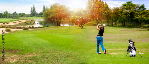 Fotografia, Obraz Panorama of Golfer hit sweeping golf ball on blurred  beautiful golf course with sunshine on background