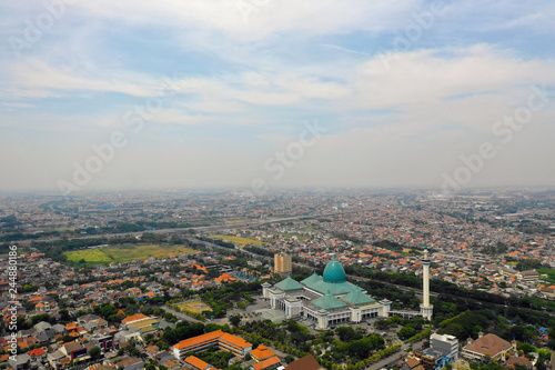 aerial view cityscape city Surabaya with mosque Al Akbar, highway, buildings and houses. mosque in Indonesia Al Akbar in Surabaya, Indonesia. beautiful mosque with minarets on island Java Indonesia.