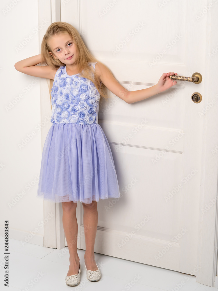 A little girl is standing by the door. A little girl is standing by the door.