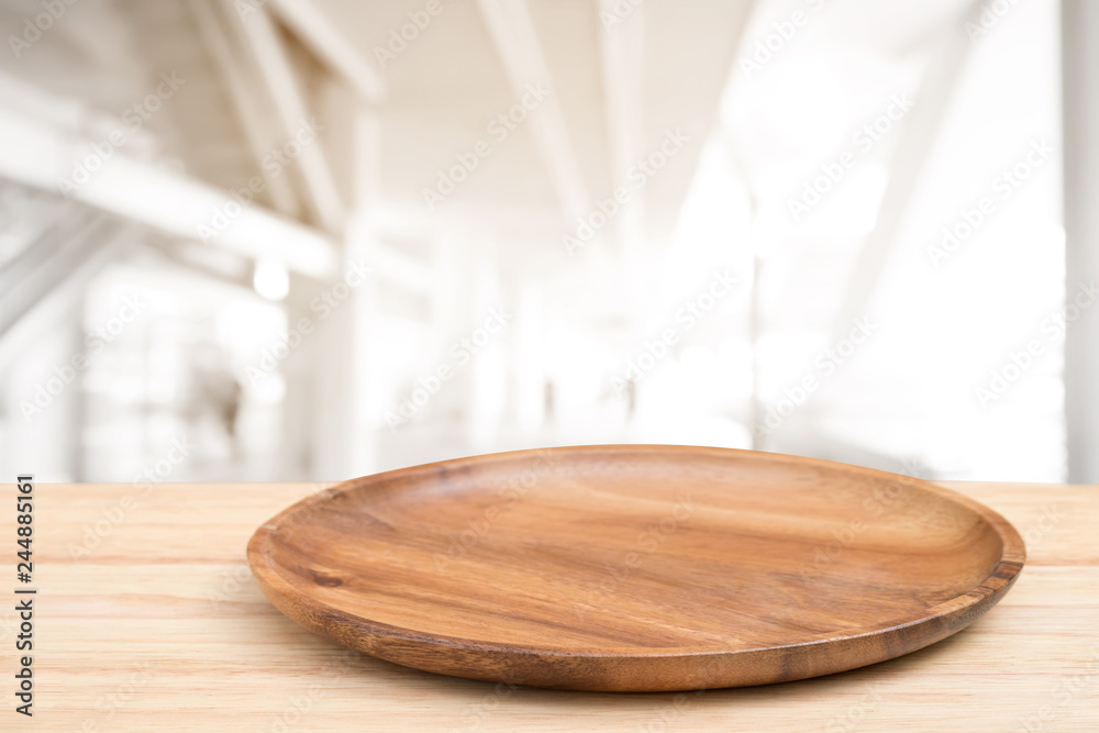 Perspective wooden table and wooden tray on top over blur mall background, can be used mock up for montage products display or design layout.