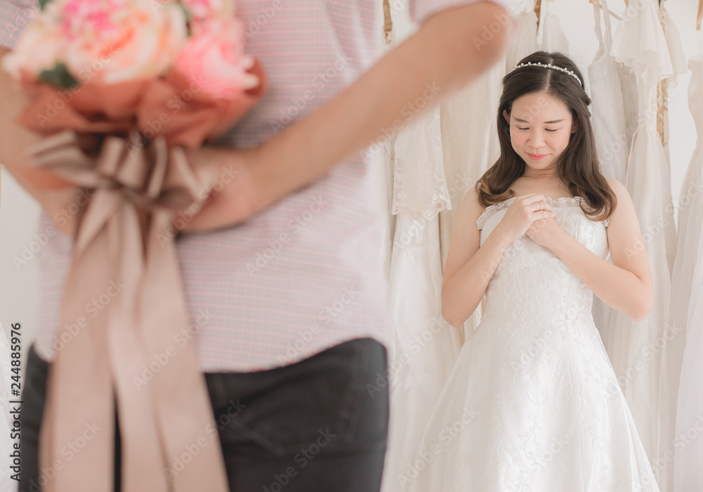 Groom hiding flower behind back in order to surprise bride,Woman positive emotion and face astonished,Romantic and sweet moment Groom hiding flower behind back in order to surprise bride,Woman positive emotion and face astonished,Romantic and sweet moment