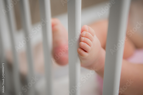 close-up of the bare feet of a baby lying in a crib