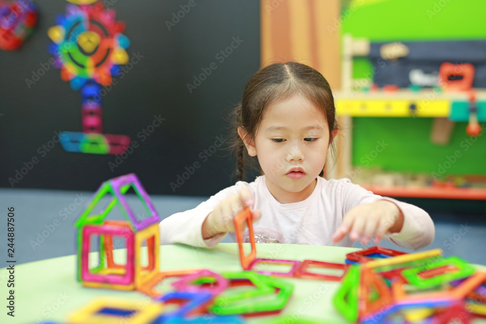 Little child girl playing Magnets toy for brain development. Little child girl playing Magnets toy for brain development.