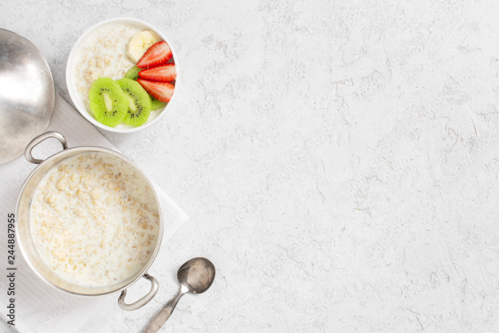 Background with oatmeal porridge and fresh fruits on the white table Background with oatmeal porridge and fresh fruits on the white table