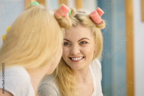 Blonde woman using hair rollers