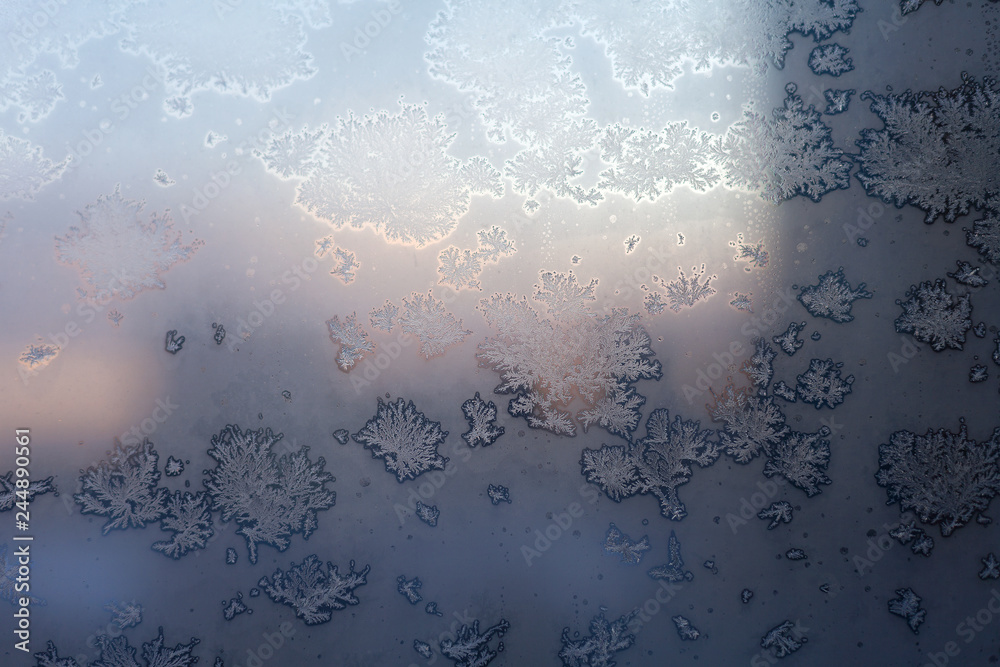 Frosty snowflake pattern on the window glass and city lights Frosty snowflake pattern on the window glass and city lights