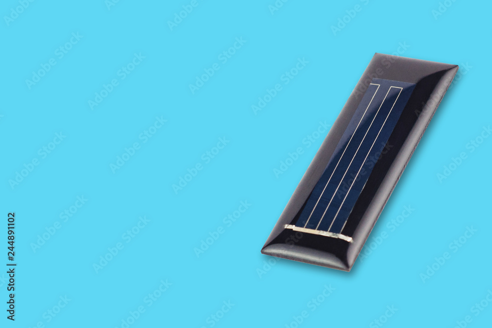 One new rectangular solar cell protected of transparent silicone or resin on blue table with copy space for your text. Green or alternative or eco energy concept