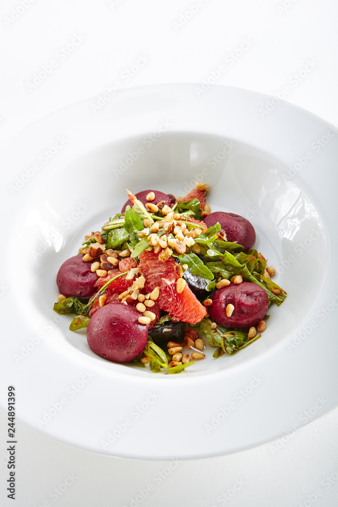 Salad with Grapefruit Pine Nuts and Arugula Garnish with Beets Hemispheres Isolated on White Background. Restaurant Exquisite Serving Dish with Fruit and Vegetables Salat Close Up Salad with Grapefruit Pine Nuts and Arugula Garnish with Beets Hemispheres Isolated on White Background. Restaurant Exquisite Serving Dish with Fruit and Vegetables Salat Close Up