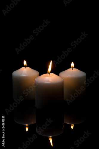 candles with reflection burning on black background with copy space