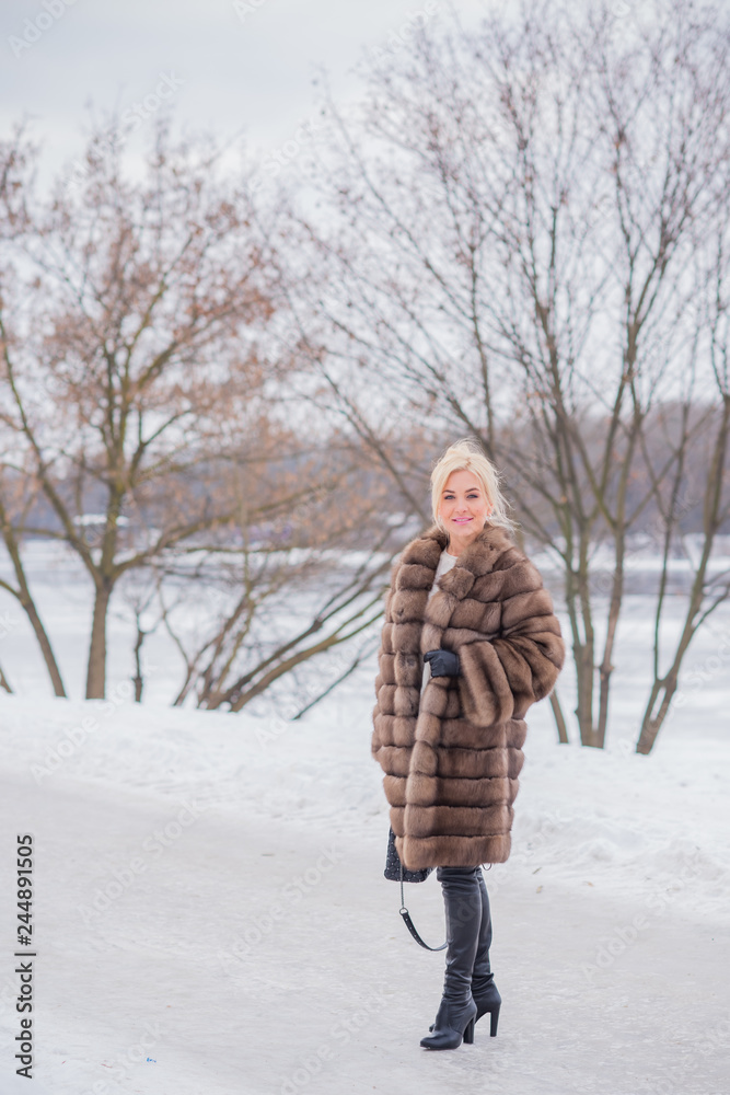 Nice elegant lady in fur coat at nature, autumn - winter season time, woman with attractive appearance Nice elegant lady in fur coat at nature, autumn - winter season time, woman with attractive appearance