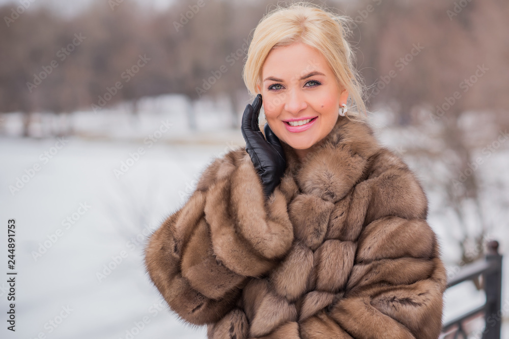 Nice elegant lady in fur coat at nature, autumn - winter season time, woman with attractive appearance Nice elegant lady in fur coat at nature, autumn - winter season time, woman with attractive appearance