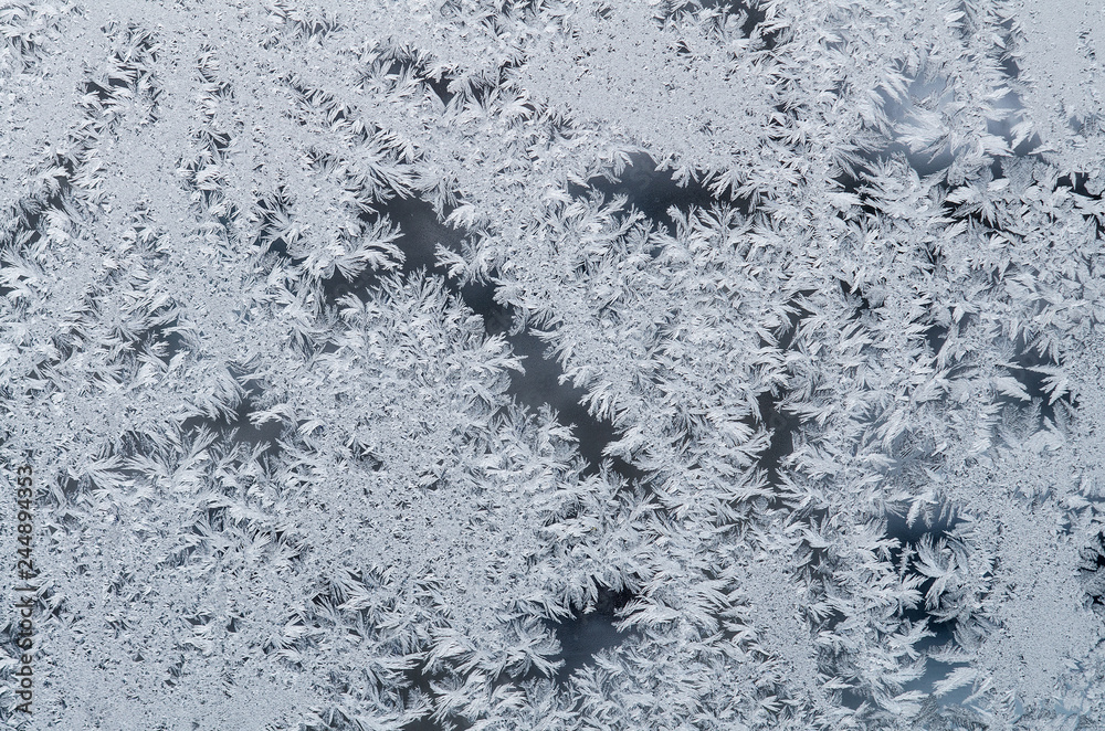On the glass frozen moisture in the winter day formed a beautiful, fantastic patterns, unpredictable compositions.