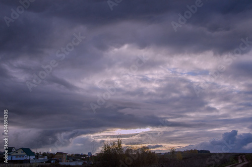 The space of the summer sky is filled with many cumulonimbus clouds above the low horizon, toned.