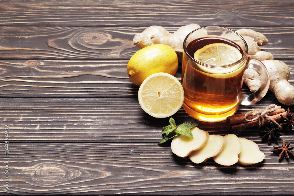 Hot Tea with lime and ginger on a wooden background. Traditional medicine. Space for text. Top view. Hot Tea with lime and ginger on a wooden background. Traditional medicine. Space for text. Top view.