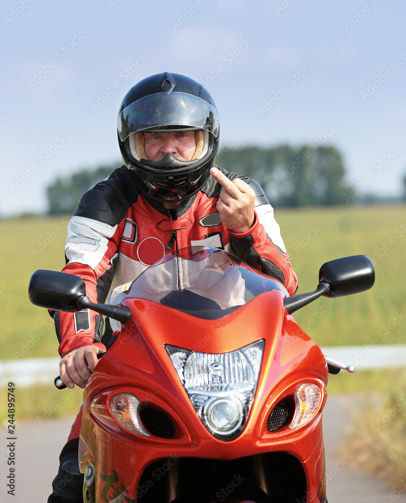 Motorradfahrer zeigt Mittelfinger StockFoto Adobe Stock