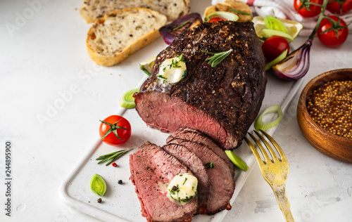 Roast beef with sauce and meat fork on white background. Copy space.