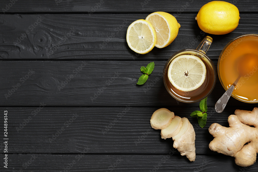 Traditional medicine. Hot tea with lemon and ginger, Honey and Mint on a black wooden background. Place for text. Top view. Traditional medicine. Hot tea with lemon and ginger, Honey and Mint on a black wooden background. Place for text. Top view.