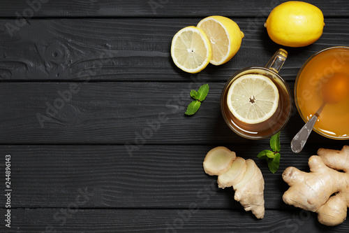 Traditional medicine. Hot tea with lemon and ginger, Honey and Mint on a black wooden background. Place for text. Top view.