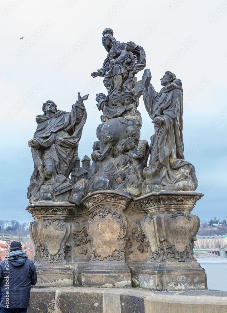 Prague, Czech Republic, Charles bridge. Sculpture of Madonna with Saints Dominic and Thomas Aquinas. In the center of the composition is the virgin Mary with little Jesus hovering over the globe