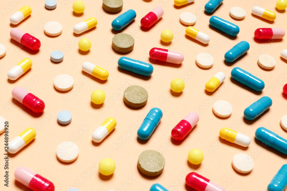 Multi-colored vitamins on a pink background. Place for text. Top view. Multi-colored vitamins on a pink background. Place for text. Top view.