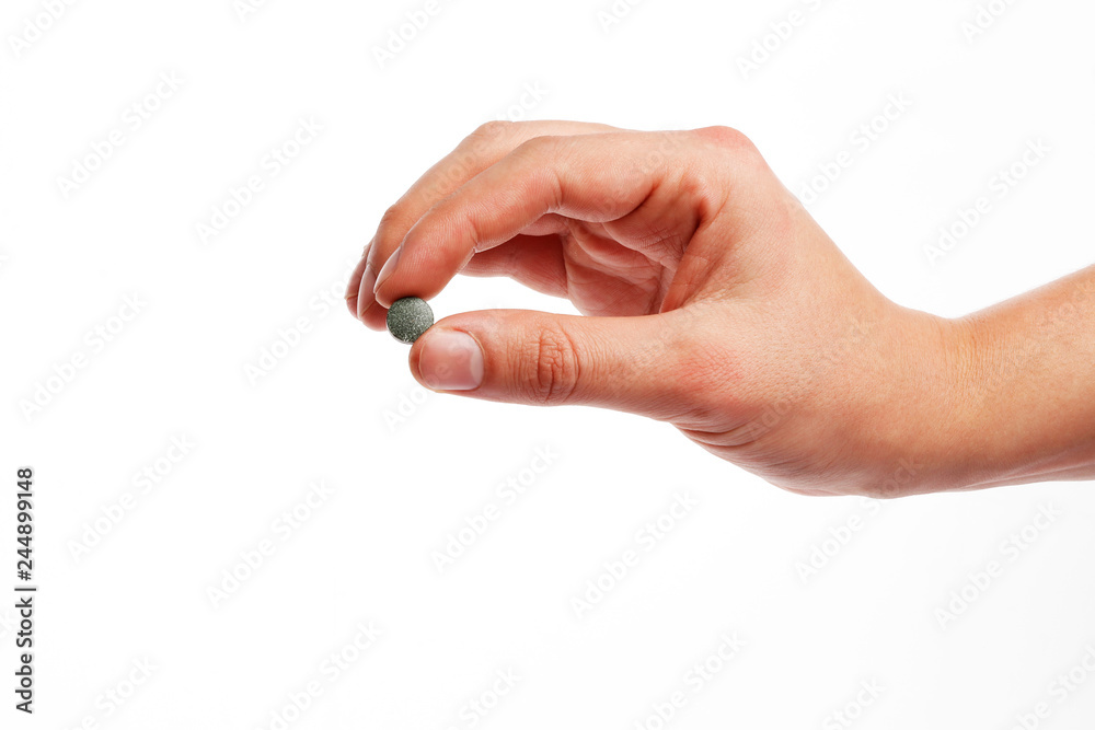 spirulina pill in hand isolated on white background spirulina pill in hand isolated on white background