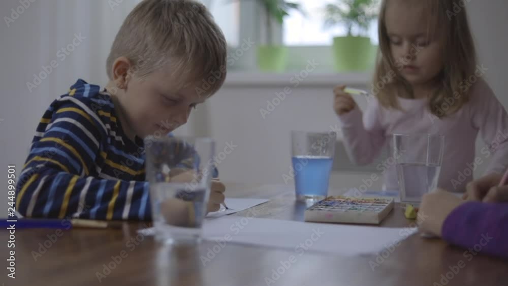 Happy children - boy and two girls is drawing with colorful paint Happy children - boy and two girls is drawing with colorful paint