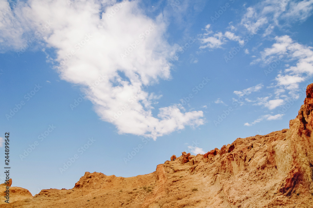 Fototapeta premium Rocks of oasis Chebika, famous landmark in Sahara desert. Cloud in shape of dragon. Tunisia.