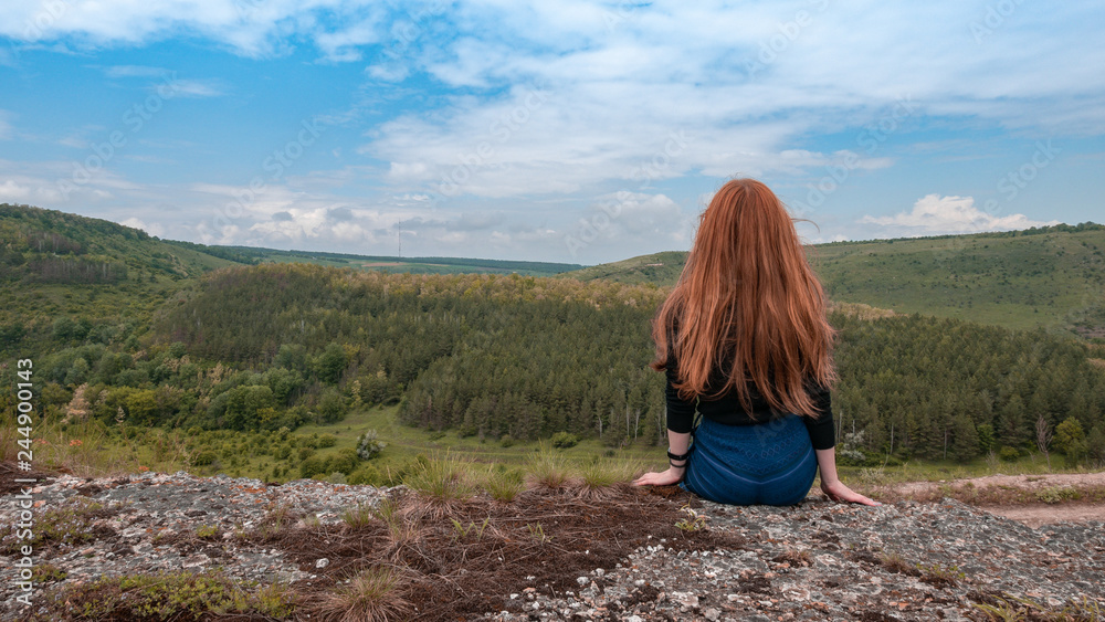 Fototapeta premium A beautiful girl with red hair enjoys great view of ukrainian forest