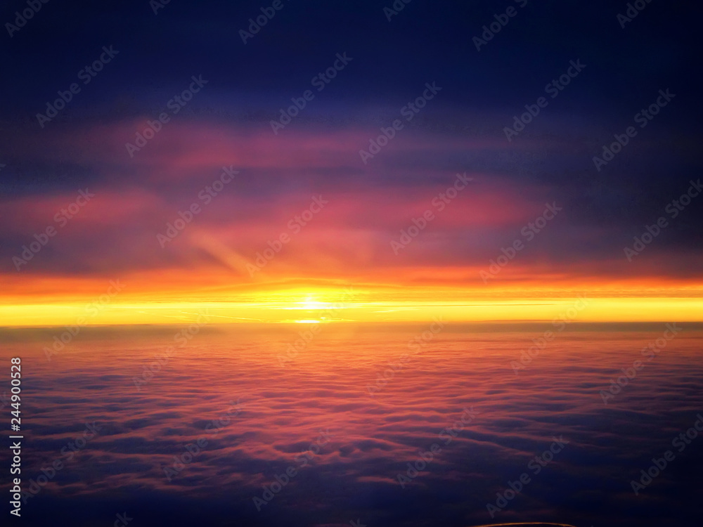red sky and sun between clouds on sunrise morning day aerial panorama airplane