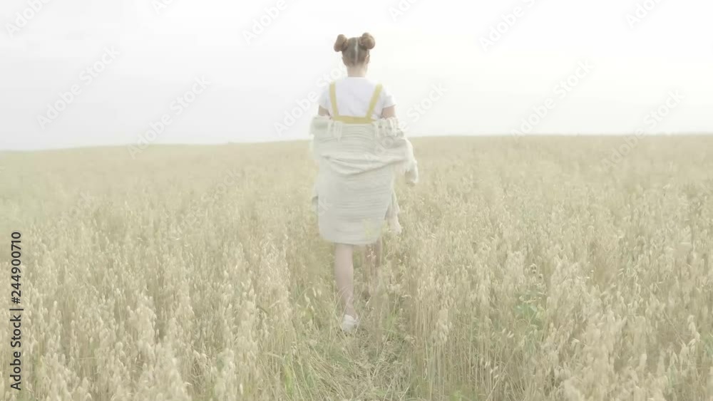 A girl walks in a wheat field A girl walks in a wheat field