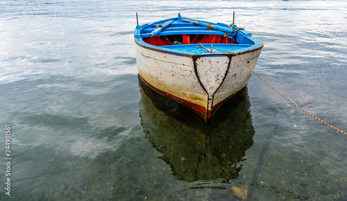 Fototapeta Naklejka Na Ścianę i Meble -  Small Old Fishing Boat in a Harbor on the Southern Mediterranean Coast of Italy