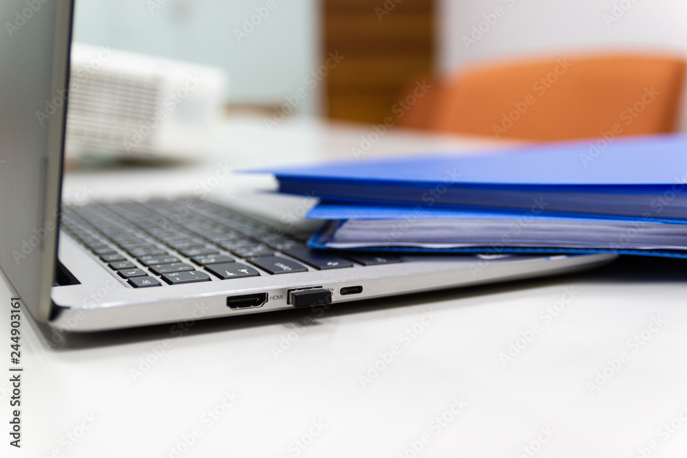 Close Up Blue file folder and Laptop Computer on desk in meeting room, business concept. Close Up Blue file folder and Laptop Computer on desk in meeting room, business concept.