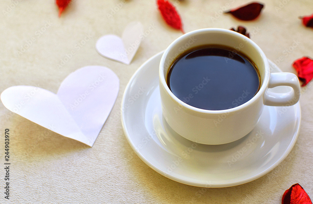 Hot mug with black coffee, heart shaped postcard and rose petals. Romance and love.