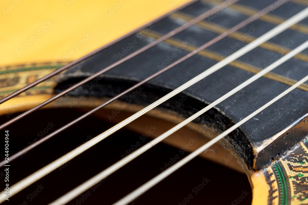 Closeup wooden classical guitar. Old classical guitar with nylon strings. Old acoustic guitar Closeup wooden classical guitar. Old classical guitar with nylon strings. Old acoustic guitar