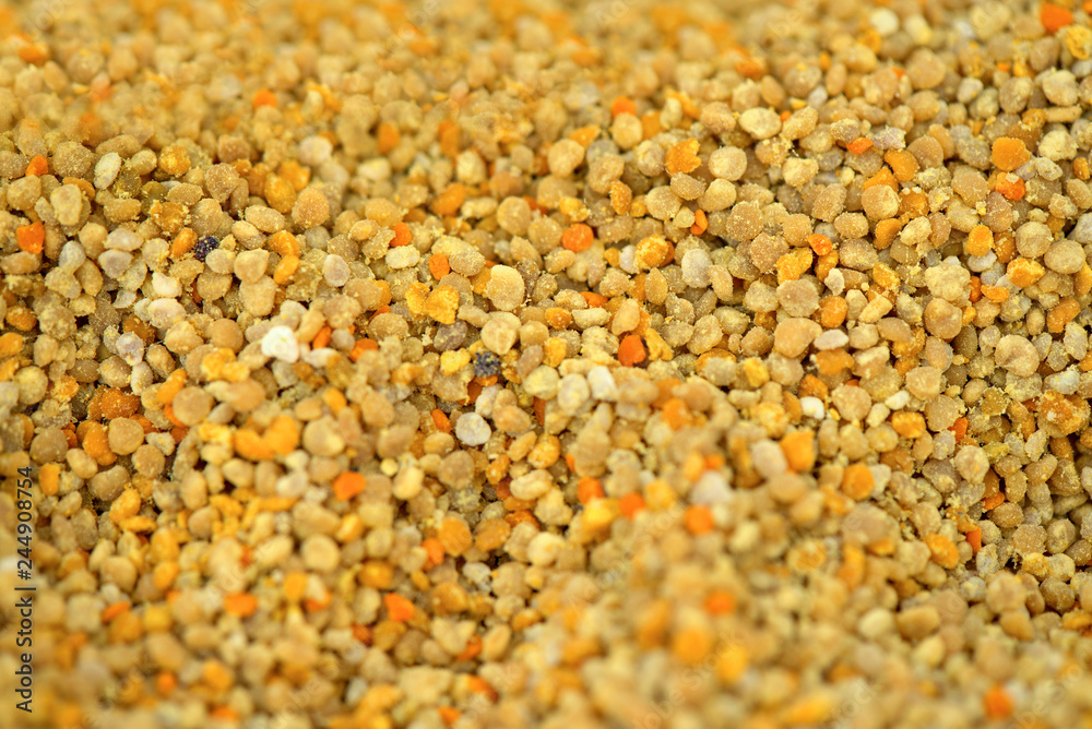 Abstract bright background of bee pollen texture. Fresh recently collected bee pollen sold at local state fair. Health benefits of bee products, natural ingredient for many recipes. Abstract bright background of bee pollen texture. Fresh recently collected bee pollen sold at local state fair. Health benefits of bee products, natural ingredient for many recipes.